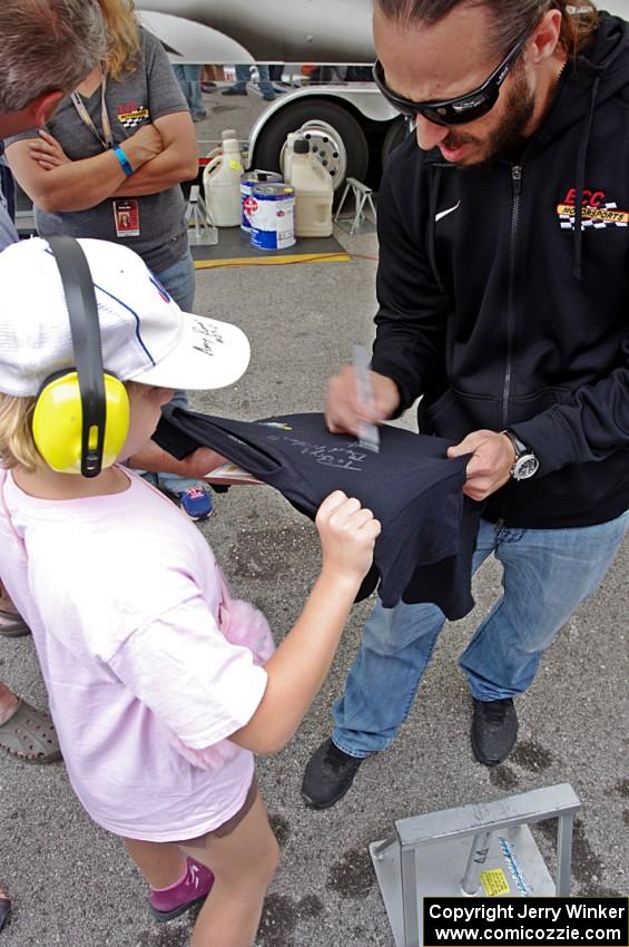 Adam Andretti signs a t-shirt for a fan.