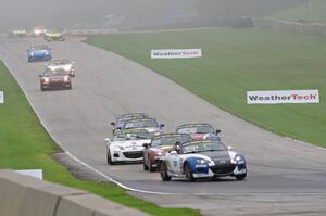 MX-5s head downhill into turn 8 in the thick fog.