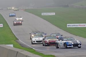 MX-5s head downhill into turn 8 in the thick fog.