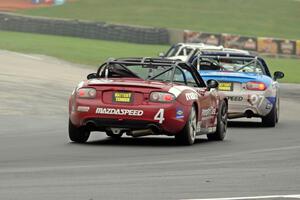 Nick Igdalsky's and Kyle Loustaunau's Mazda MX-5s follow a pair of similar cars.