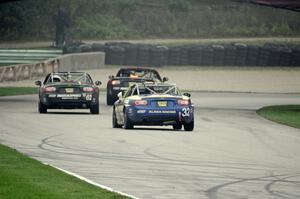 Bryan Hixon ahead of Kieron O'Rourke and Keith Jensen, all in Mazda MX-5s.