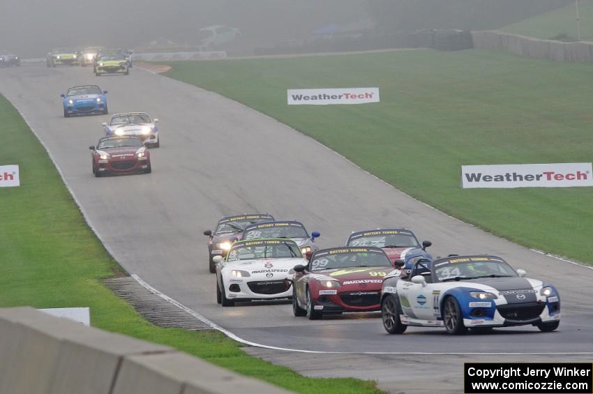 MX-5s head downhill into turn 8 in the thick fog.