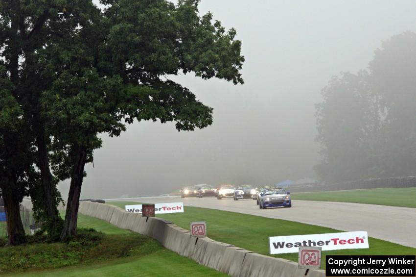 Mazda MX-5s through the Hurry Downs in the thick fog.