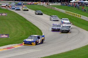 Chase Elliots's Chevy Camaro leads the field through the Hurry Downs on the first lap.