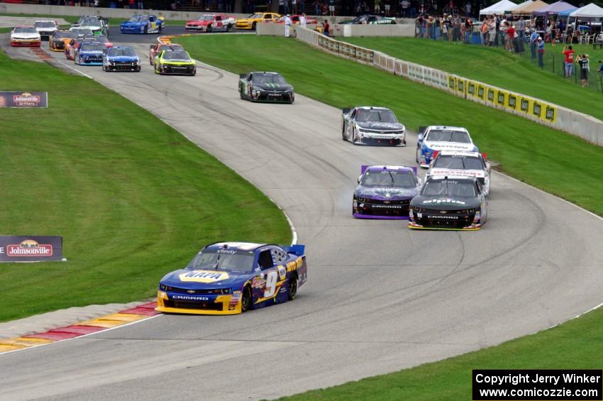 Chase Elliots's Chevy Camaro leads the field through the Hurry Downs on the first lap.