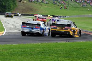 Chris Buescher's Ford Mustang and Brendan Gaughan's Chevy Camaro chase the rest of the field.