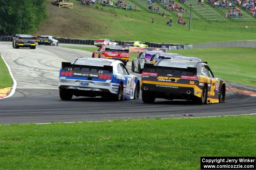 Chris Buescher's Ford Mustang and Brendan Gaughan's Chevy Camaro chase the rest of the field.