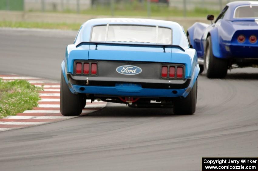 Brian Kennedy's Ford Mustang Boss 302 chases Kent Burg's Chevy Corvette