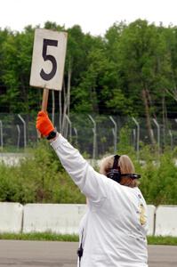 Karen Carson holds up the 5-minute sign on the false grid