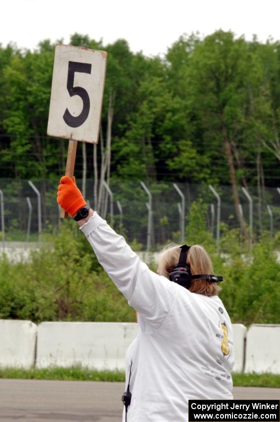 Karen Carson holds up the 5-minute sign on the false grid