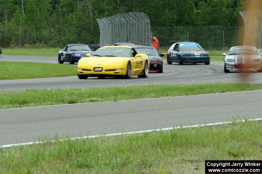 The pace car brings Race Group 1 through the carousel as the rain starts.