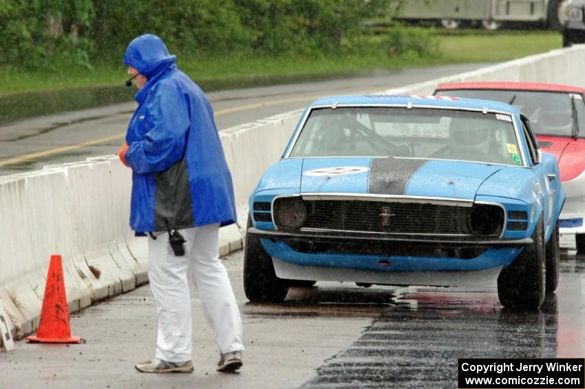 Karen Carson walks in front of Brian Kennedy's Ford Mustang Boss 302 and Ed Dulski's Datsun 240Z on the false grid.