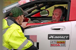 Darrell Peterson sits in his SPO Chevy Corvette while chatting with Will Cammack.