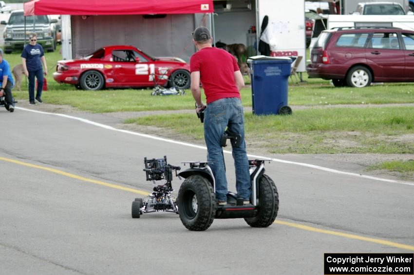 A film crew does a low-level shot of cars leaving the grid.