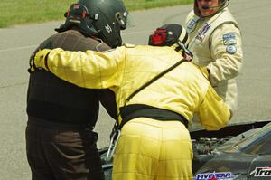 John Atwell is helped from his car by safety workers after pulling off course at turn 12.