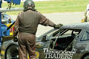 An exhausted John Atwell leans against his Chevy Camaro.