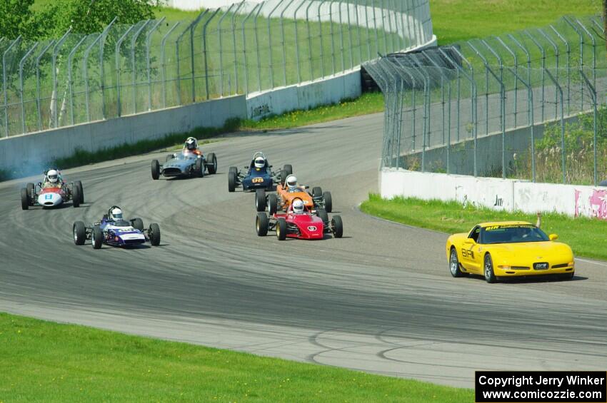 The field streams into turn ten on the pace lap.