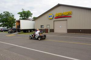 Mark Utecht drives his pit golf cart down the paddock road.