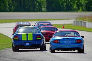 John Glowaski's STL Dodge Neon ACR and Rick Buan's Spec Miata Mazda Miata chase down the rest of the pack.