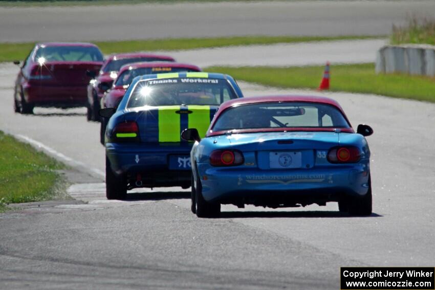 John Glowaski's STL Dodge Neon ACR and Rick Buan's Spec Miata Mazda Miata chase down the rest of the pack.