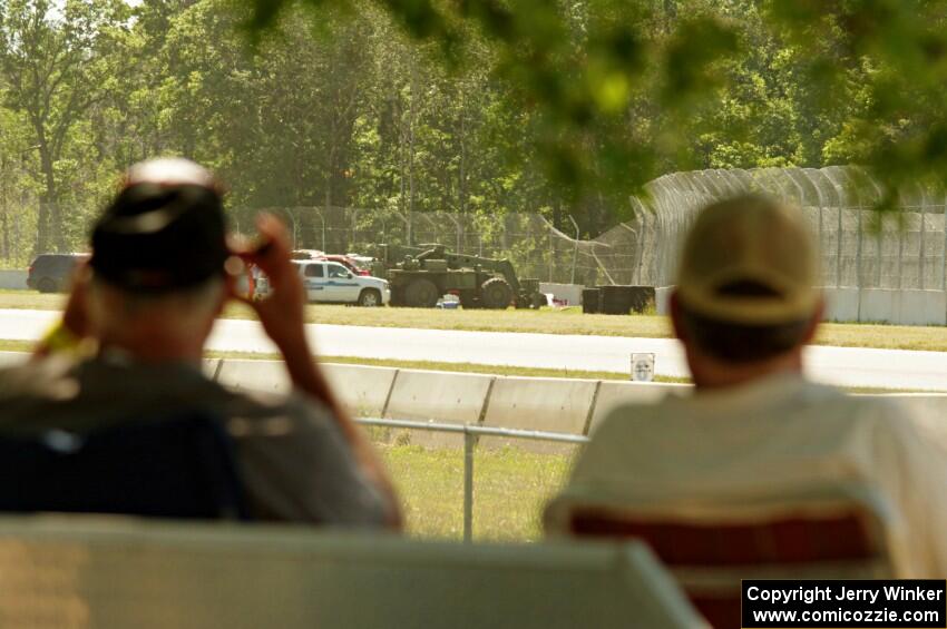 Two spectators view safety crews working at turn 3.