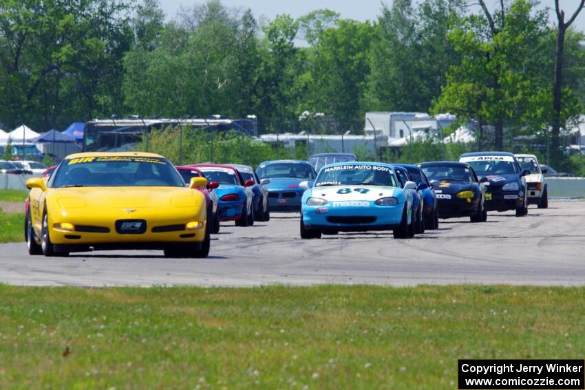 The Spec Miata and smaller production class field comes into turn 12 on the pace lap.