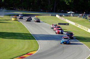 The TCB field streams through the Hurry Downs on lap 1.