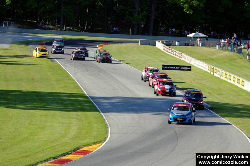 The TCB field streams through the Hurry Downs on lap 1.