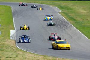 The formula car field streams into turn six on the pace lap.