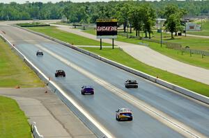 Five cars head down the front straight.