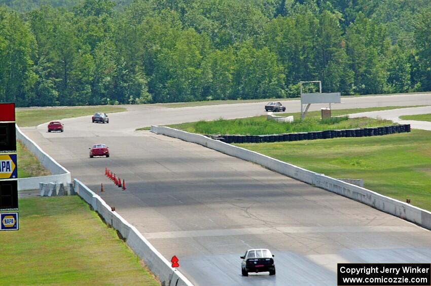 Five cars head down the front straight and into turn one.