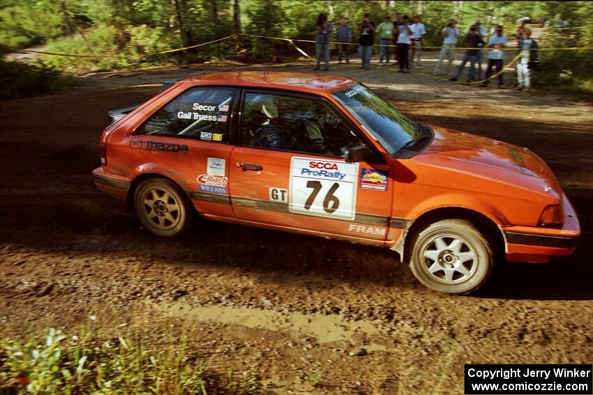 Gail Truess / Jeff Secor Mazda 323GTX powers out of a sharp left-hander on SS13 (Steamboat).