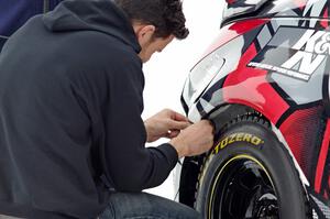 Josh Robinson makes ziptie repairs to the bumper of his Nissan 350Z.