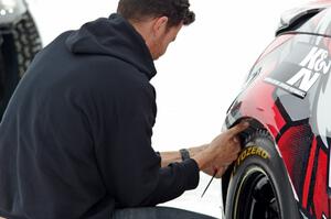 Josh Robinson makes ziptie repairs to the bumper of his Nissan 350Z.