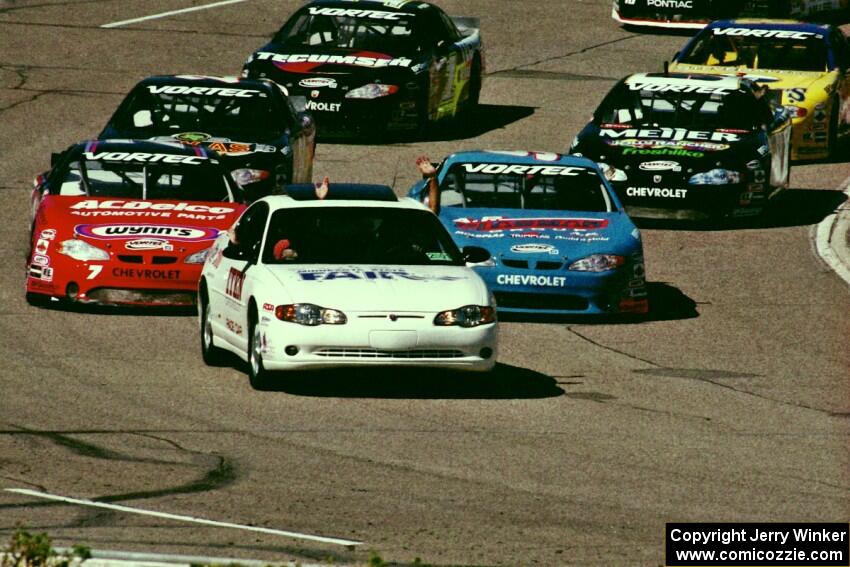 The field comes out of turn 4 led by the pace car.