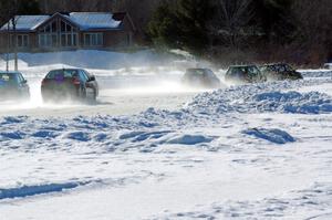 A group of cars goes down the front straight after a start.