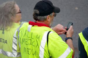 Tom Buchkoe, with an official media vest, checks on the start time.