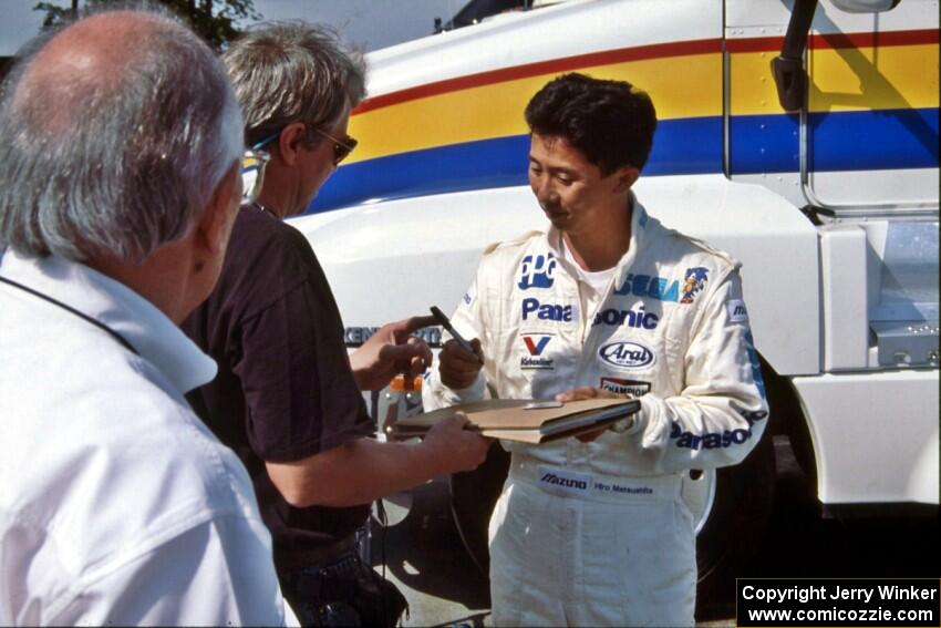 Hiro Matsushita signs an autograph in the paddock.