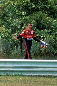 Eddie Cheever walks back to the pits and waves to the fans after DNF'ing.