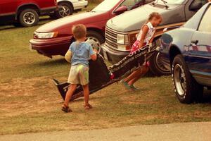 Kids bringing home parts of a Shelby Can-Am car after the race.