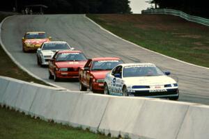 Five cars stream downhill into turn 5.