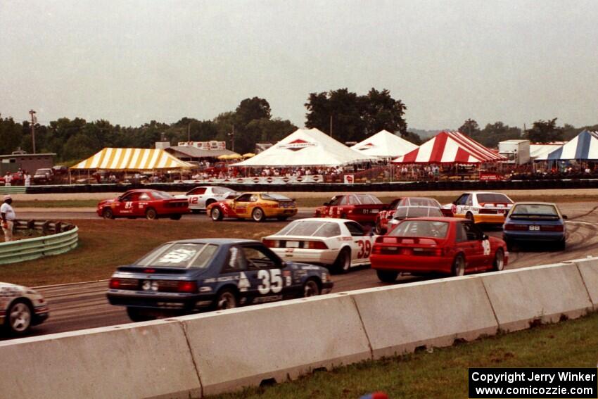 Scott Hoerr's Olds Achieva SCX, Jeff Nowicki's Chevy Camaro and Rick Bye's Porsche 968 lead a gaggle of cars through turn 5.