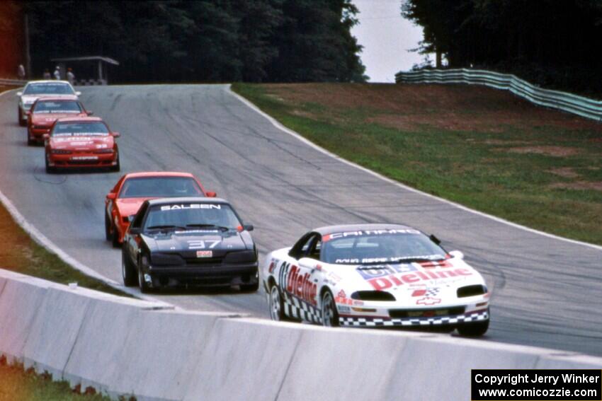 Six cars stream downhill into turn 5.