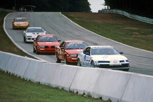 Five cars stream downhill into turn 5.