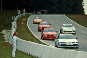 Five cars stream downhill into turn 5.