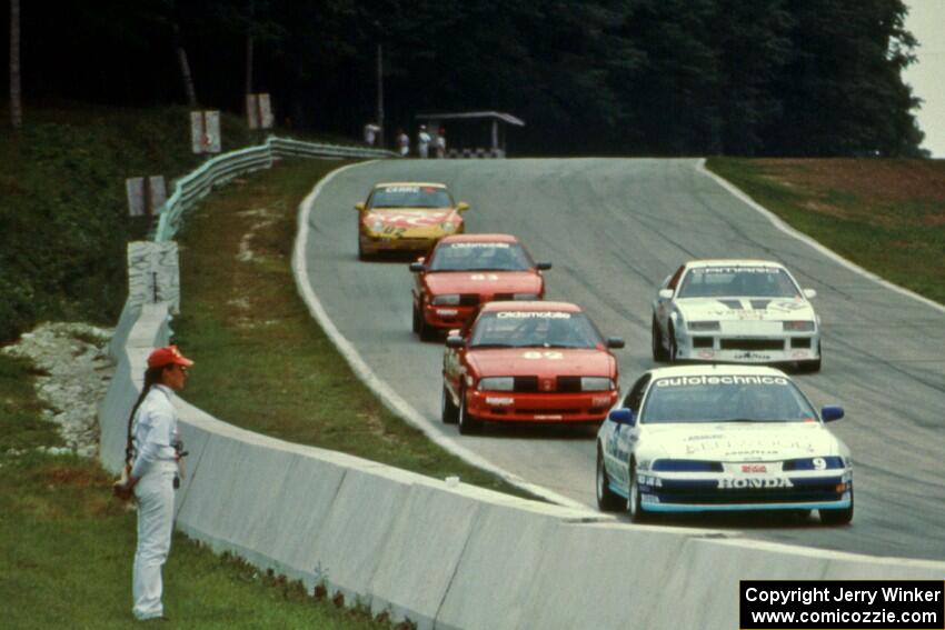 Five cars stream downhill into turn 5.