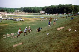 A group of kids try "sledding" down Fireman's Hill on sheets of waxed cardboard.