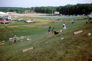 A group of kids try "sledding" down Fireman's Hill on sheets of waxed cardboard.