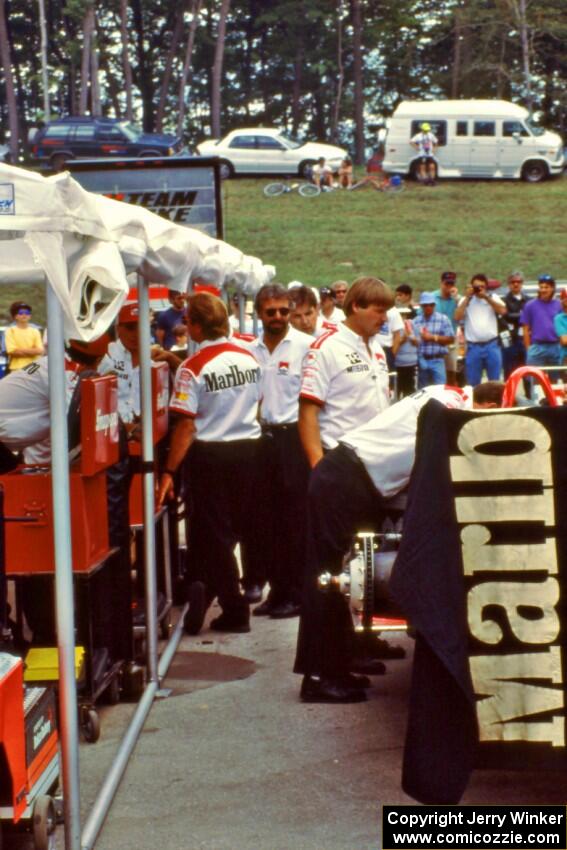 Rick Mears, dead center, helps with the Penske crew.