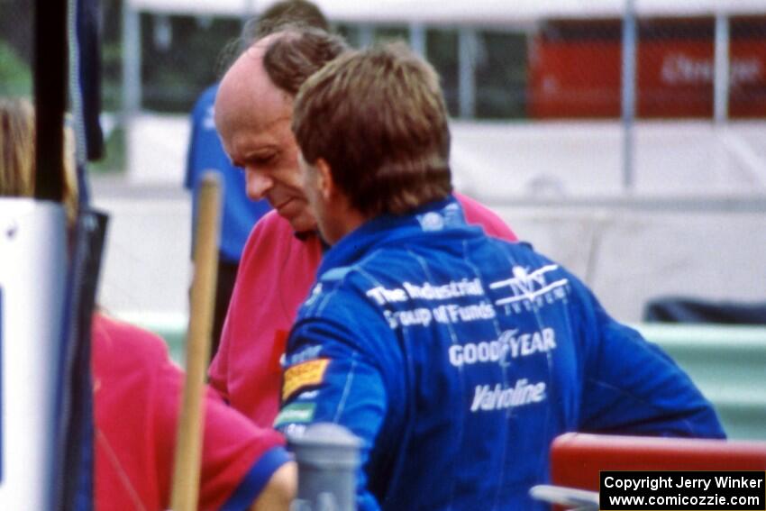 Scott Goodyear and Derrick Walker converse on pit lane.